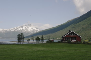 Obraz premium дом в зеленая долина на фоне гор в Норвегии