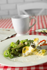 Roasted asparagus with fried egg on plate on table background
