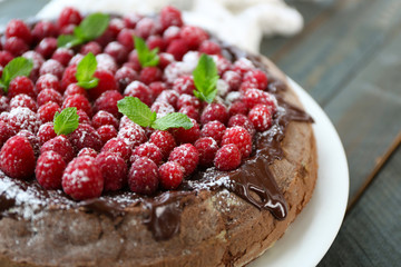 Cake with Chocolate Glaze and raspberries on wooden background