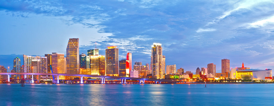 Miami Florida at sunset, cityscape of modern downtown buildings illuminated with reflections in the waters of Biscayne BAy