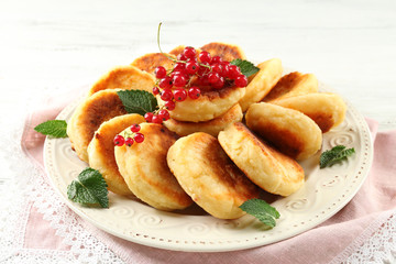 Fritters of cottage cheese with berries in plate, closeup