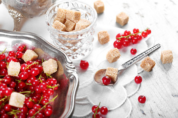 Fresh red currants with sugar on table close up