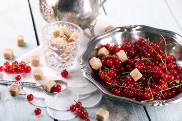 Fresh red currants with sugar on table close up