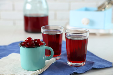 Sweet homemade cherry juice on table, on light background