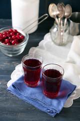 Sweet homemade cherry juice on table, on color background