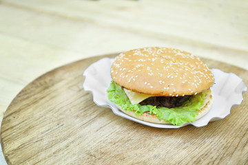 Tasty hamburger on wooden table close up
