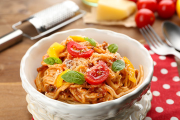 Homemade Spaghetti Bolognese with parmesan cheese in white bowl, on color wooden background