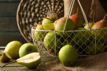Ripe tasty pears in basket on table close up
