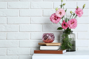 Beautiful flowers with books on brick wall background