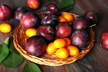 Ripe plums on wooden table, closeup