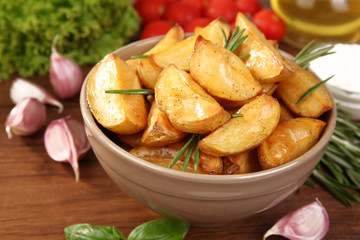 Baked potato wedges on wooden table, closeup