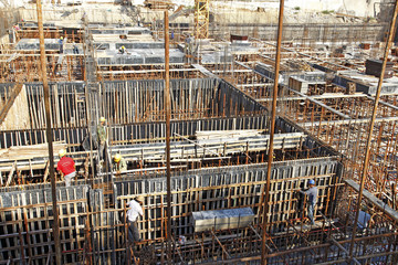 workers in the construction site making reinforcement metal fram
