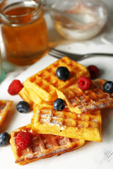 Sweet homemade waffles on tray, on light background