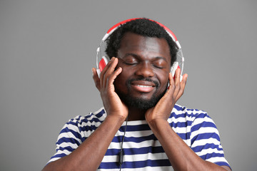 African American man with headphones on grey background
