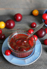 Tasty homemade plum jam on wooden background