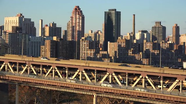 Wide shot of the Queensboro Bridge and traffic with the New York skyline background.
