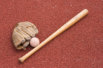 baseball bat with ball and glove on a rubber background