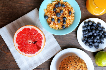 Tasty cornflakes with fruits and berries on table close up