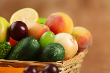 Heap of fresh fruits and vegetables in basket close up