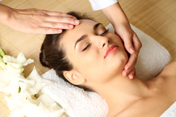 Fototapeta na wymiar Young woman in beauty spa salon enjoying head massage