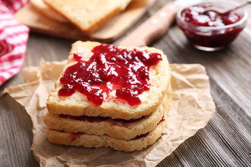 Bread with butter and homemade jam on crumpled parchment, closeup