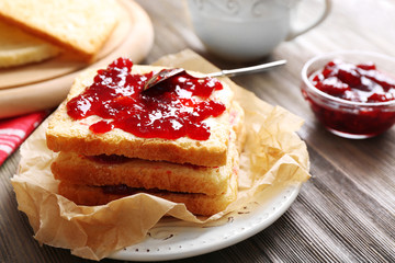 Bread with butter and homemade jam on crumpled parchment, closeup