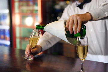 Bartender holding glass with champagne, close-up