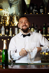 Bartender wipes glasses at work
