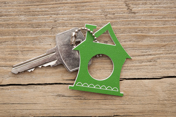 Symbol of the house with silver key on vintage wooden background