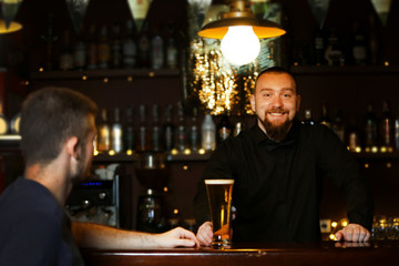 Young man drinking beer in bar