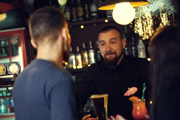 Young man and woman drinking in bar