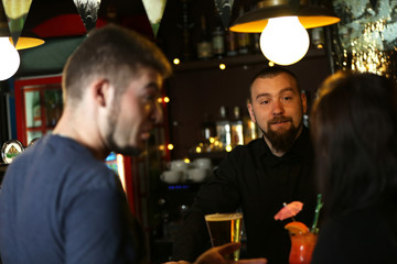 Young man and woman drinking in bar
