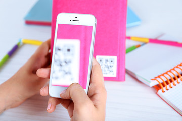 Woman scanning voucher code with mobile phone close up