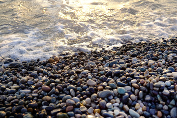 Dark wet pebbles beach with sea waves