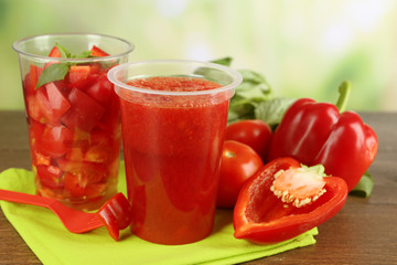 Vegetable and fruit  salad and healthy fresh drink in plastic cups on wooden background. Colorful diet concept