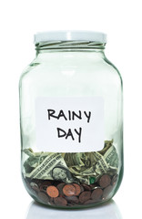 Glass jar with with a white rainy day label and some money in it
