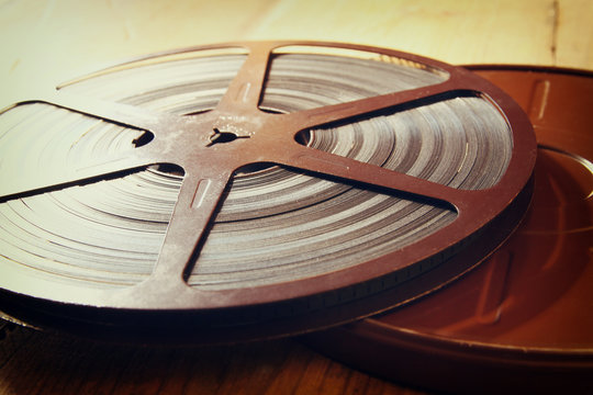 image of old 8 mm movie reel over wooden background. retro style image