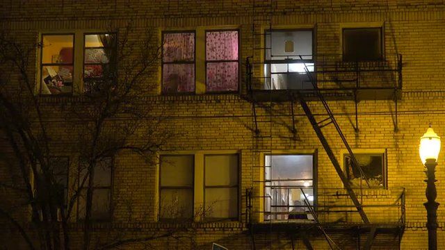 Generic establishing shot of an urban tenement or apartment complex at night.