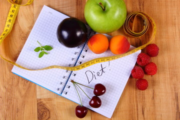 Fruits and centimeter with notebook, slimming and healthy food