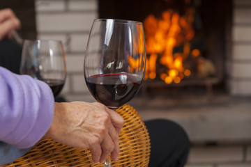 enjoying red wine at fireplace