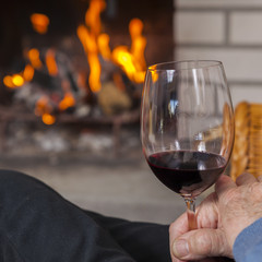enjoying red wine at fireplace in winter