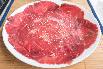 Slide raw beef on a dish on the table