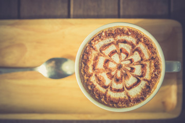 A Latte Coffee art on the wooden desk vintage color