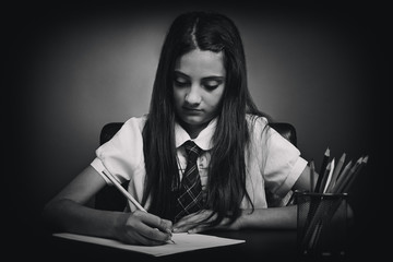 Schoolgirl sits at a school desk