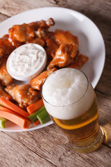 American fast food: buffalo wings and beer close-up vertical
