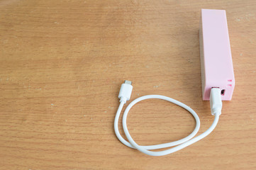 Pink powerbank on wood table and copyspace