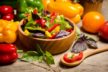 salad from bell pepper and basil in a wooden bowl and vegetables