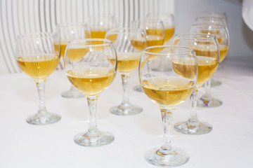 Glasses of wine on the table. The table decorations. The white tablecloth. Plates and white wine. The Banquet, serving. Party in the restaurant. Christmas , New year and wedding. Alcohol.
