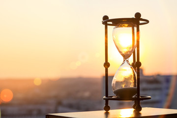 hourglass at sunset - obrazy, fototapety, plakaty