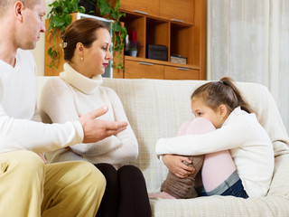 serious parents scolding daughter